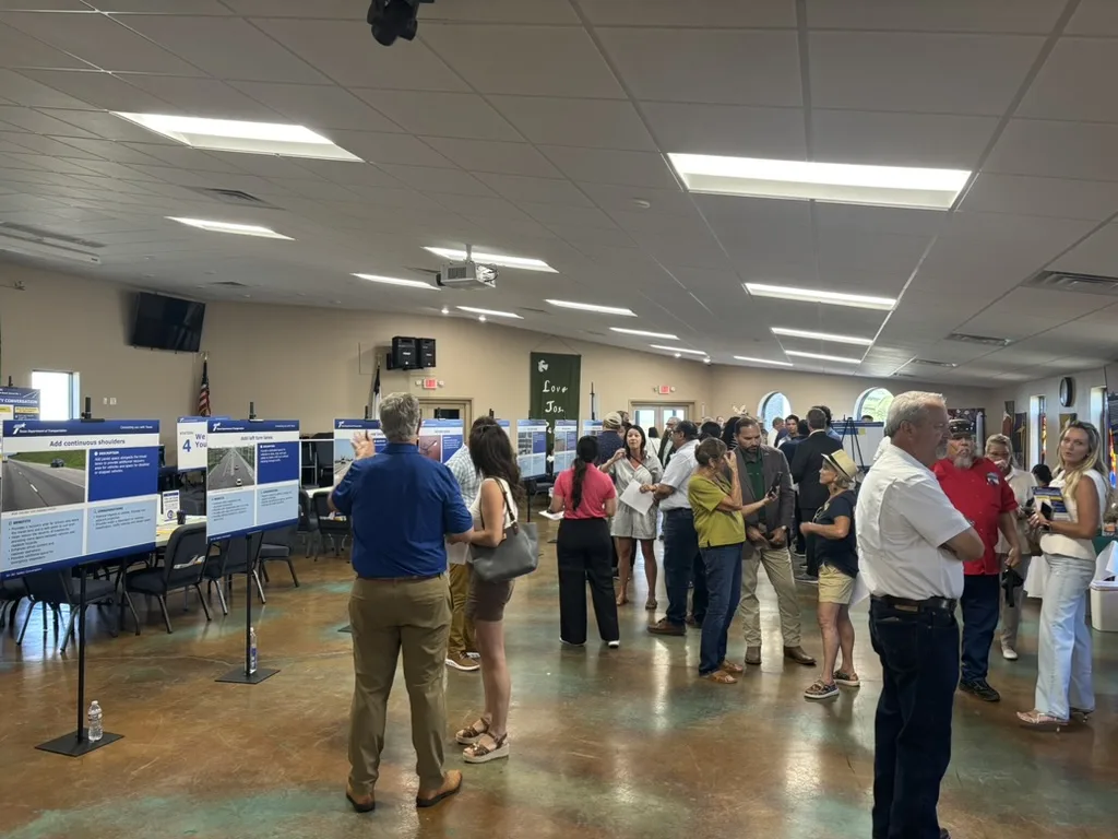 Residents crowd the TxDOT SH 361 safety open house, reading proposal boards on easels